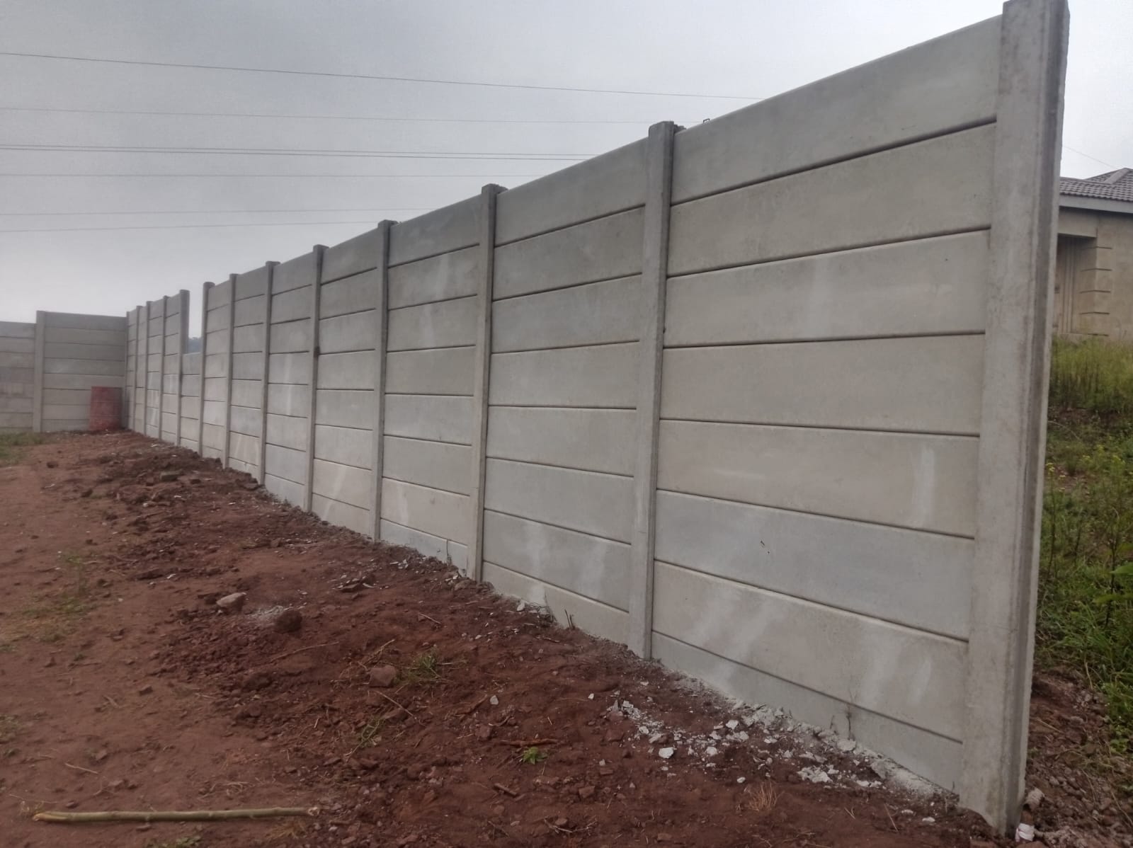 Completed horizontal-plank precast boundary wall installation