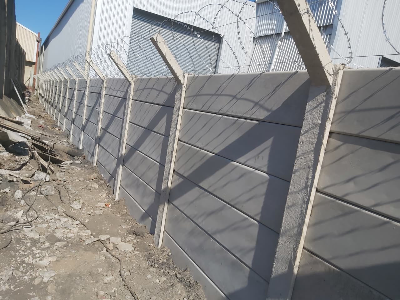 Precast boundary wall with razor wire at an industrial site