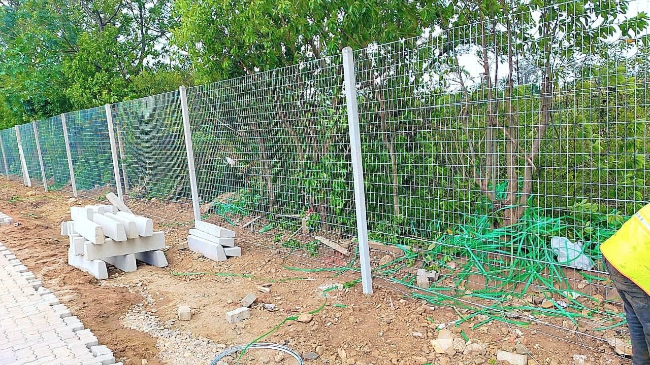 Wire mesh fencing installation along a boundary line