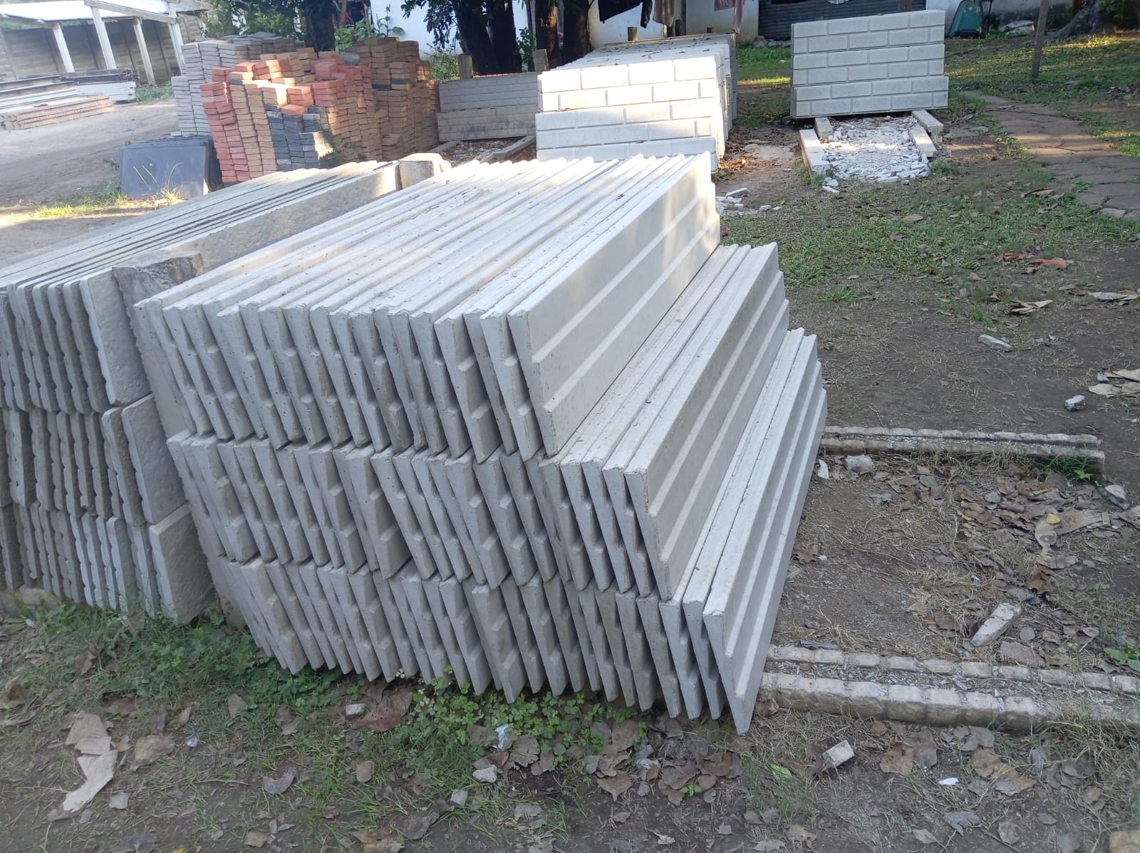 Stacked precast concrete fence panels in the yard