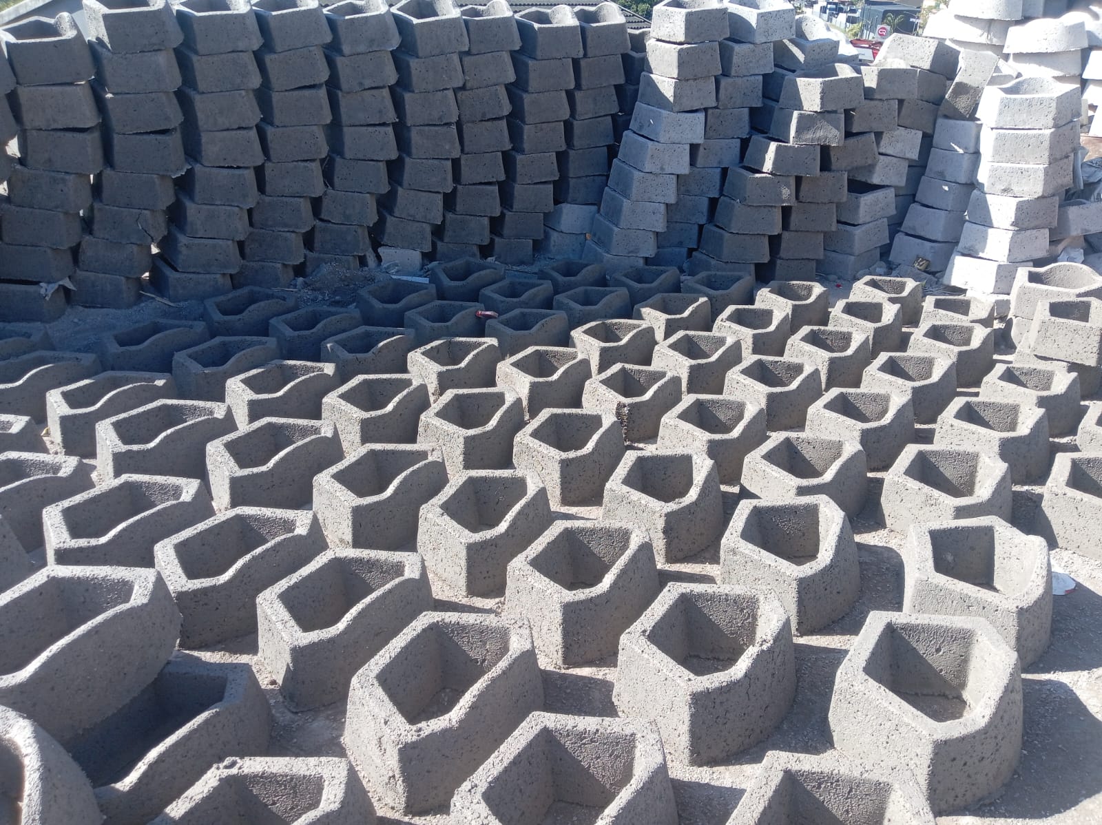Rows of curing retaining blocks and pavers at the production yard